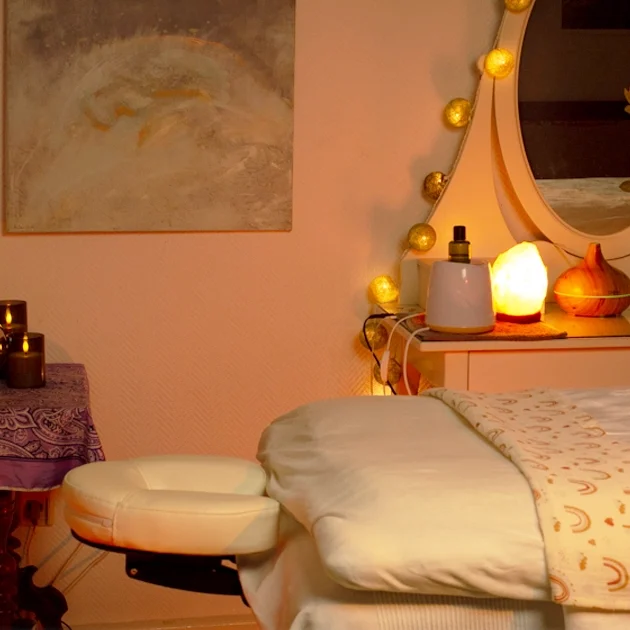 HannoverMassage_Studio_Blick Privater Massageraum mit Frisierkommode, Salzkristalllampe, Mandala-Wandbehang und Kerzenlicht
